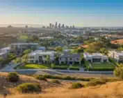 California hillside homes overlooking a city skyline.